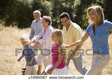 Stock Photo - Three generations of family walking in park. Fotosearch