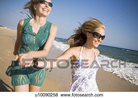 Two women walking on beach View Large Photo Image Stock Photo - Two women walking on beach. Fotosearch