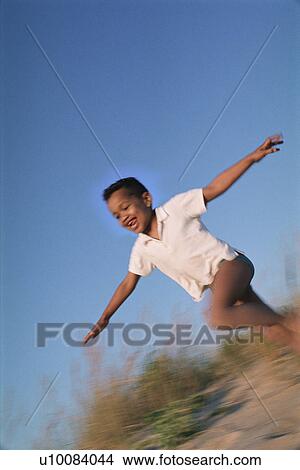 Young boy running in sand dunes View Large Photo Image Picture - Young boy running in sand dunes. Fotosearch