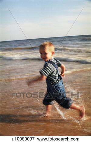 Young boy running on beach View Large Photo Image Stock Photo - Young boy running on beach. Fotosearch