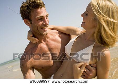 Stock Photo - Young couple on beach. Fotosearch
