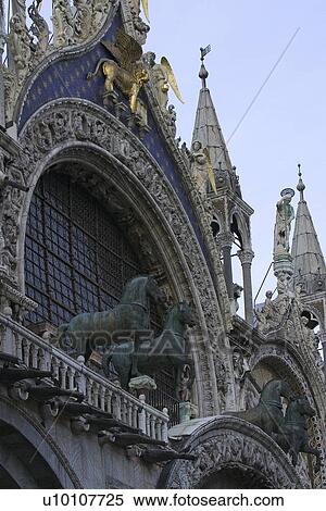 Gold winged lion on starred blue background of St Marks Basilica. Bronze Quadriga horses in foreground. View Large Photo Image Stock Photography - Gold winged lion on starred blue background of St Marks Basilica. Bronze Quadriga horses in foreground.. Fotosearch