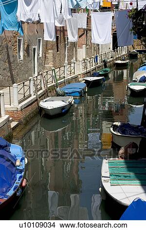 Assorted small boats moored a quite canal side with laudry hanging on clothing lines View Large Photo Image Picture - Assorted small boats moored a quite canal side with laudry hanging on clothing lines. Fotosearch