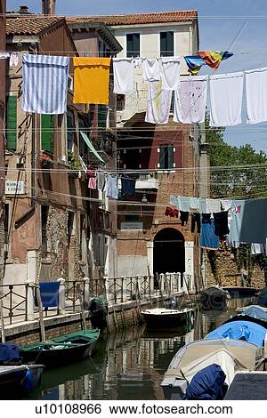 Assorted small boats moored a quite canal side with laudry hanging on clothing lines View Large Photo Image Stock Photograph - Assorted small boats moored a quite canal side with laudry hanging on clothing lines. Fotosearch