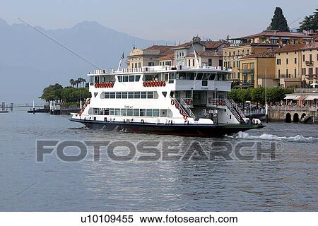 Stock Photography - Car ferry on Lago di Como Italy departing Bellagio hills and town in background. Fotosearch