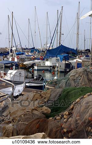 Stock Photograph - Fishing Boats and nets in Jaffa Harbour Israel. Fotosearch