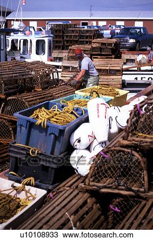 Stock Image - Lobster pots, fishing nets, fishing boat and shed, Trocadie Bay, Prince Edward Island. Fotosearch