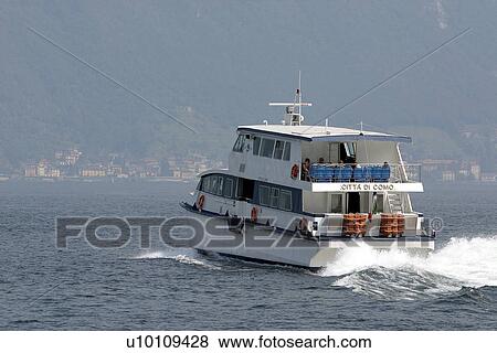 Stock Photo - Passenger ferry on Lago di Como Italy hills and town in background. Fotosearch