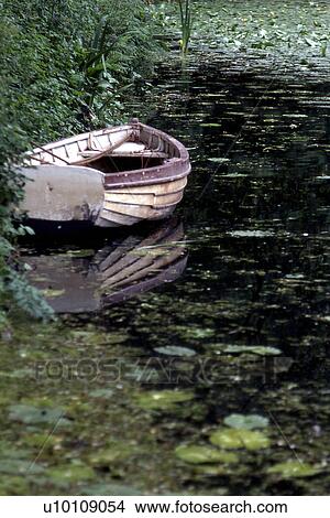 Picture - rowboat in pond with lillypads Wallingham Northumberland. Fotosearch