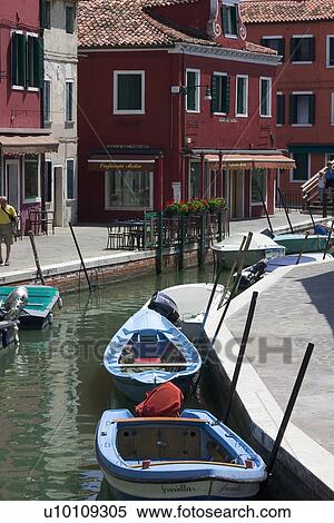 Stock Photography - Small boats in sunlit canal at Buranno Island, Venezia. Fotosearch