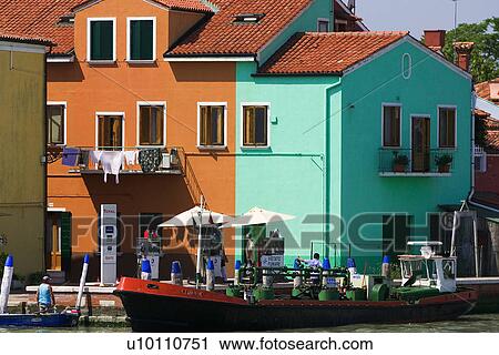 Barge in canal at Buranno, Venezia. Two bright coloured buildings, orange and green/blue. Total petrol station on canal side. View Large Photo Image Stock Image - Barge in canal at Buranno, Venezia. Two bright coloured buildings, orange and green/blue. Total petrol station on canal side.. Fotosearch