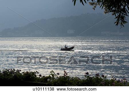 speedboat on Lago di Como, Mountains in background Italy View Large Photo Image Stock Photo - speedboat on Lago di Como, Mountains in background Italy. Fotosearch
