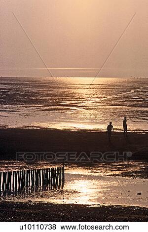 Sunset over beach, tide out, wooden posts in foreground with people Heacham UK View Large Photo Image Stock Photo - Sunset over beach, tide out, wooden posts in foreground with people Heacham UK. Fotosearch