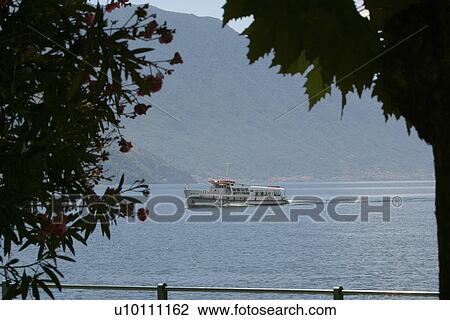 Tour boat on Lago di Como, Mountains in background Italy View Large Photo Image Stock Image - Tour boat on Lago di Como, Mountains in background Italy. Fotosearch