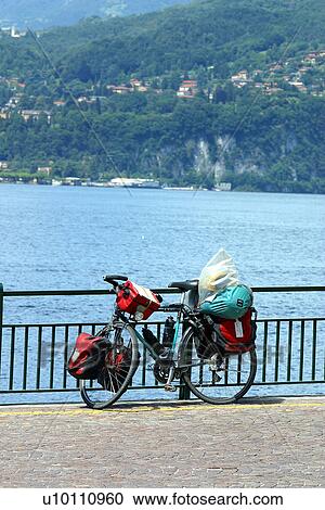 Stock Image - Touring bike against railing in front of lake, Lago di Como. Italy. Fotosearch