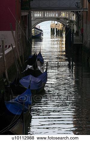 Quiet canal, bridge in distance, gondolas moored at side View Large Photo Image Stock Photo - Quiet canal, bridge in distance, gondolas moored at side. Fotosearch