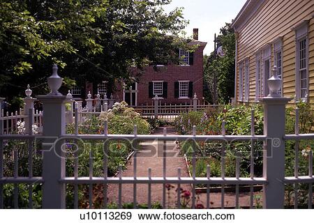 Stock Photo - view of garden in front of yellow house. Fotosearch