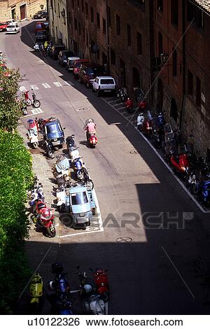 Stock Photograph - Motor bikes parked on Siena street. Fotosearch