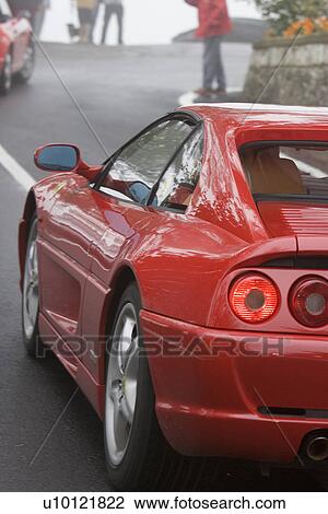 Red sports car driving on the road View Large Photo Image Stock Image - Red sports car driving on the road. Fotosearch
