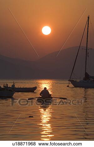 Stock Photo - Dusk, Fishing Boat, Lake, Mountain, Oar. Fotosearch