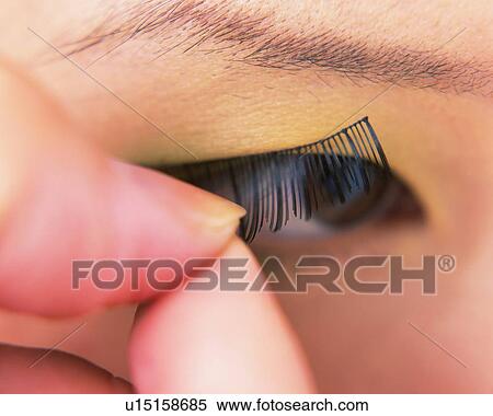 applying false eyelashes