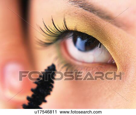 Stock Image - A Woman Applying Mascara, Differential Focus. Fotosearch