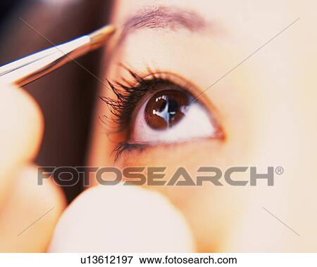 Stock Photo - A Woman Drawing Eyebrow, Looking Up, Differential Focus. Fotosearch