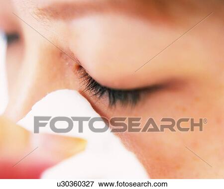 Stock Photo - A Woman Removing Makeup with a Cotton, Differential Focus. Fotosearch