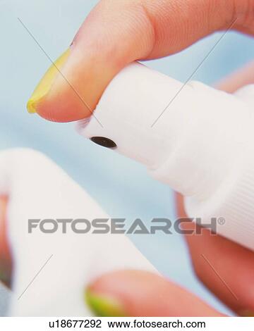 Stock Image - Closed Up Image of a Hand Spraying on a Cotton, Differential Focus. Fotosearch