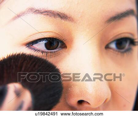 Stock Image - Young Woman Applying Face Powder, Close Up, Differential Focus. Fotosearch