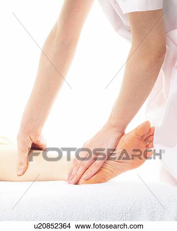 Aesthetician Who Massages Bottom of Woman's Foot, Side View View Large Photo Image Picture - Aesthetician Who Massages Bottom of Woman's Foot, Side View. Fotosearch