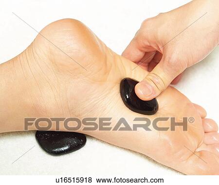 Stock Photo - Aesthetician Who Pushes Woman's Foot With Stones, High Angle View, Close Up. Fotosearch