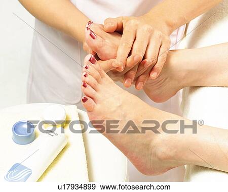 Stock Photo - Aesthetician Who Rubs Cream on Woman's Leg, Side View. Fotosearch