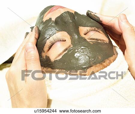 Aesthetician Who Rubs Mud Pack on Woman's Face, High Angle View View Large Photo Image Picture - Aesthetician Who Rubs Mud Pack on Woman's Face, High Angle View. Fotosearch