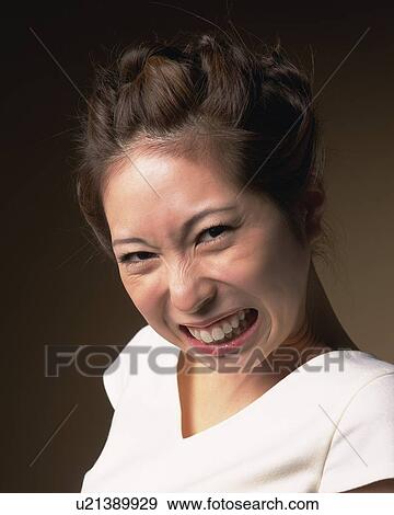 Stock Photo - Angry Young Woman, Side View, Looking at Camera. Fotosearch