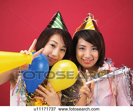 Stock Photo - Two Young Women Having a Party, Front View, Looking at Camera. Fotosearch