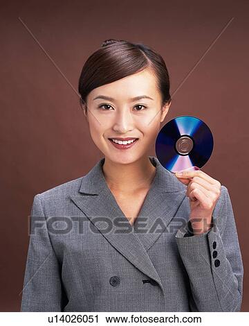 Stock Image - Businesswoman holding CD in hand, Studio, Portrait. Fotosearch