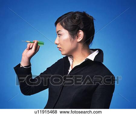 Stock Photo - Businesswoman playing darts, Studio, Portrait. Fotosearch