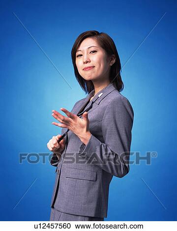 Stock Image - Businesswoman smiling at camera, Studio, Portrait. Fotosearch