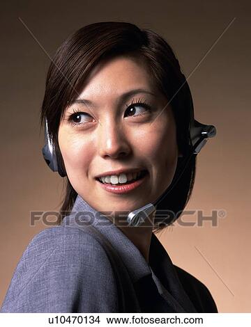 Businesswoman talking with headset, Studio, Portrait View Large Photo Image Picture - Businesswoman talking with headset, Studio, Portrait. Fotosearch