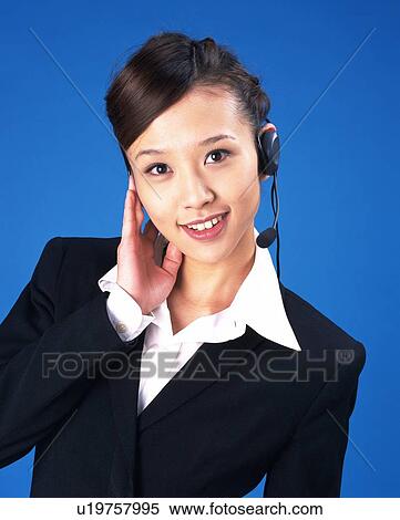 Stock Photography - Businesswoman talking with headset, Studio, Portrait. Fotosearch