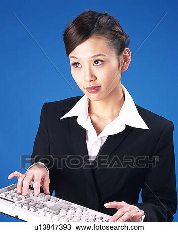Stock Image - Businesswoman typing keyboard, Studio, Portrait. Fotosearch