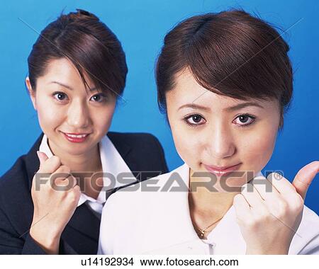 Picture - Two Businesswomen lookingat camera with victory sign, Studio, Portrait. Fotosearch