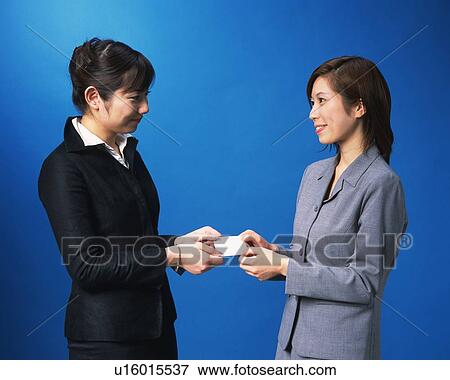 Stock Photo - Two Businesswomen smiling at each other, Studio, Portrait. Fotosearch