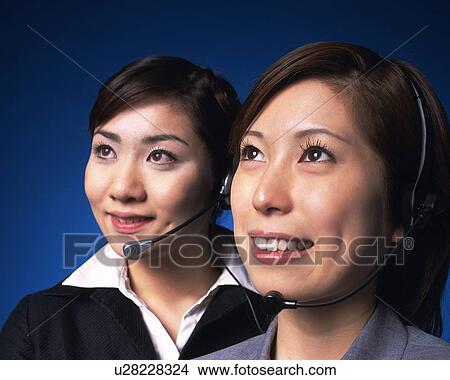Picture - Two Businesswomen with headsets smiling, Studio, Portrait. Fotosearch