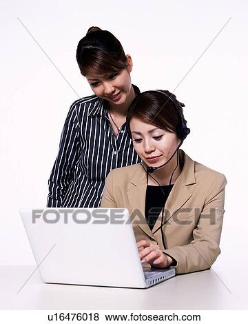 Stock Photo - Two Businesswomen working on laptop computer, Studio, Portrait. Fotosearch