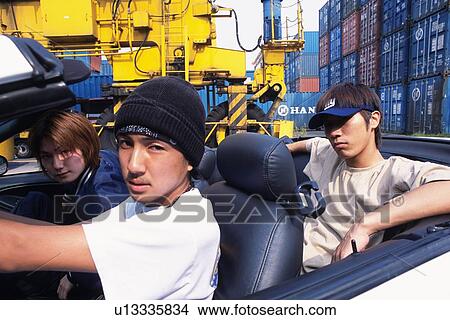 Group of three young adult men driving convertible car, Outdoors View Large Photo Image Picture - Group of three young adult men driving convertible car, Outdoors. Fotosearch