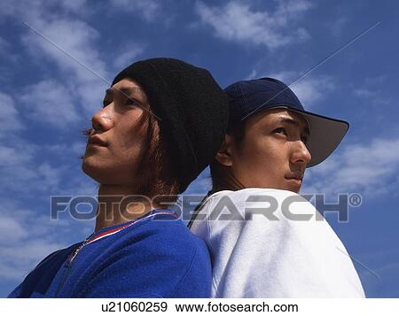 Stock Photo - Group of two young adult men poing, Outdoors. Fotosearch
