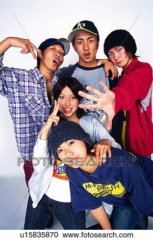 Stock Image - Group of young adult men and women poing, Studio. Fotosearch
