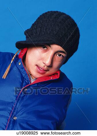 Stock Photography - Young adult man looking at camera, studio, Portrait. Fotosearch